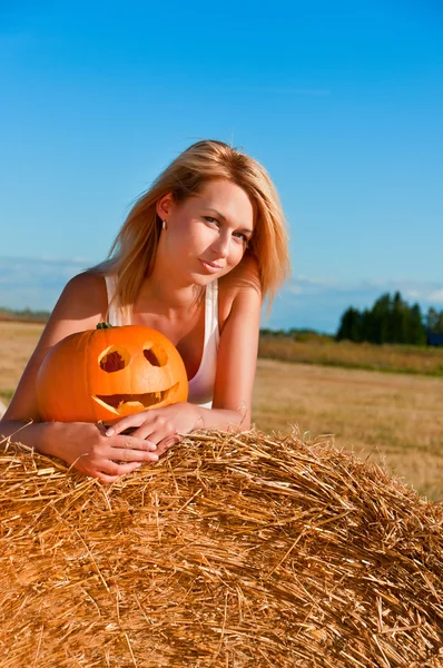 Woman in jeans shorts posing on a bale — Stock Photo, Image