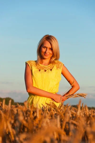 Vestido amarelo mulherengo feliz em trigo dourado — Fotografia de Stock