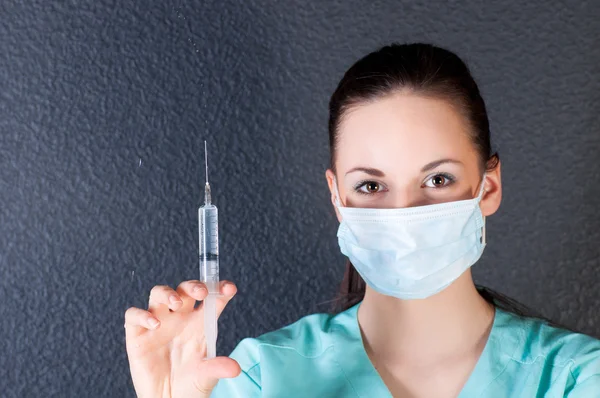 Verpleegkundige of arts met spuit en masker — Stockfoto