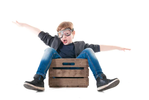 Молодий пілот хлопчика літає на дерев'яній коробці — стокове фото