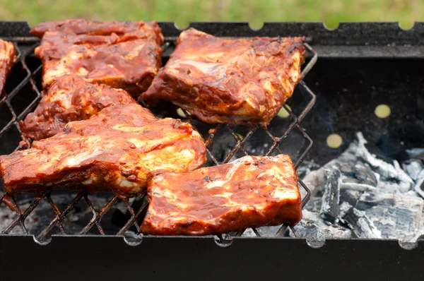 Costelas de churrasco na grelha com carvão vegetal — Fotografia de Stock