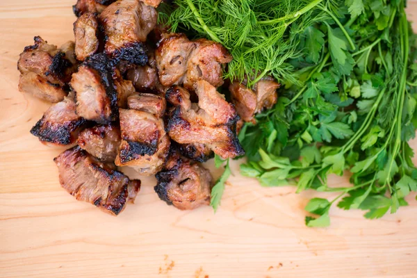 Carne alla griglia, verde su un piatto di lana — Foto Stock