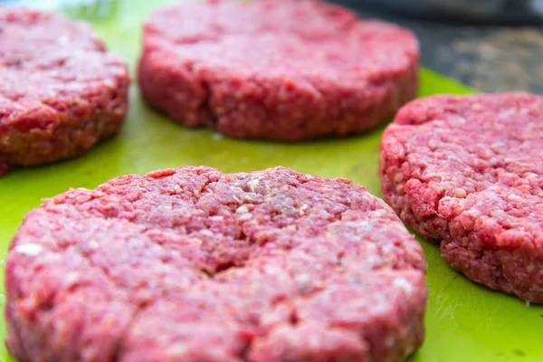 Syrové hovězí hamburgery zblízka na prkýnko — Stock fotografie