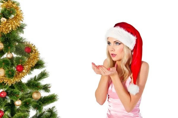 Woman in santa claus hat blows on open hands — Stock Photo, Image