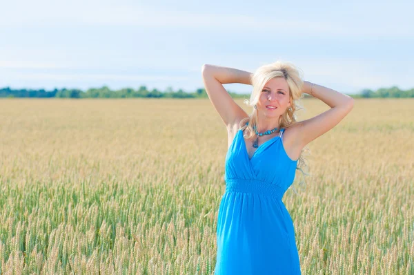 Happy womanin blue dress in golden wheat. — Stock Photo, Image