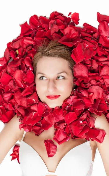 Rosenblad runt en vacker kvinnas ansikte — Stockfoto