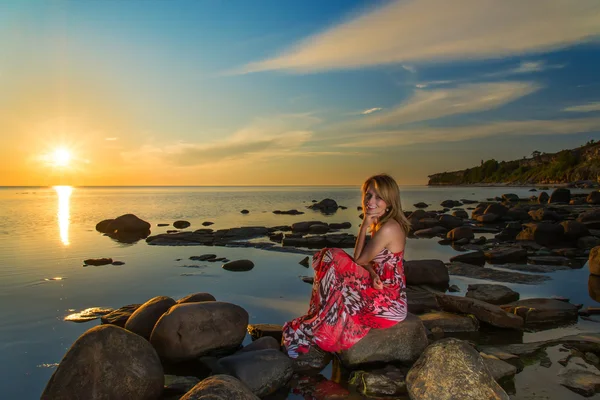 Frau in Kleid und Sonnenuntergang auf einem Meer — Stockfoto