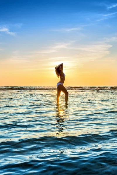 Kvinnan i vit bikini poserar i ett hav — Stockfoto