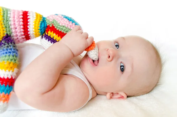 Adorável bebê brincando com colorido feito à mão brinquedo de crochê no fundo branco — Fotografia de Stock