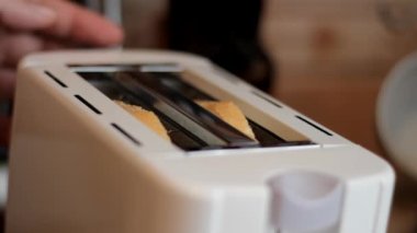 Beyaz ekmek dilimleri elektrikli tost makinesinde kızartılır. Sığ alan derinliği