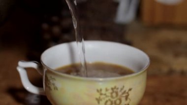 Çaydanlıktan kaynar su bir kahve bardağına dökülür. Sığ alan derinliği