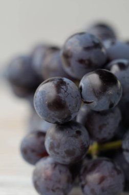 Arka planda hafif çekimde bir demet taze üzüm. Sığ alan derinliği