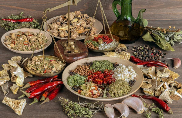 still life with dried mushrooms, scales and spices in wooden bowls on a wooden table. Preparation of mushroom seasoning. Ingredients and spices for cooking mushroom seasoning. Mushroom theme.