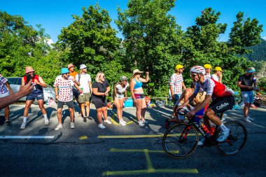 Cycling fans lining the route up Alpe d'Huez during the 2022 edition of the Tour de France and the riders passing through