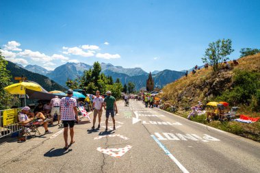 Cycling fans lining the route up Alpe d'Huez during the 2022 edition of the Tour de France and the riders passing through