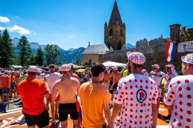 Cycling fans lining the route up Alpe d'Huez during the 2022 edition of the Tour de France and the riders passing through