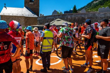 Cycling fans lining the route up Alpe d'Huez during the 2022 edition of the Tour de France and the riders passing through