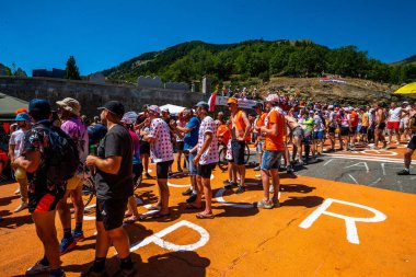 Cycling fans lining the route up Alpe d'Huez during the 2022 edition of the Tour de France and the riders passing through