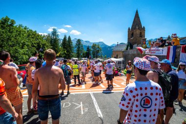 Cycling fans lining the route up Alpe d'Huez during the 2022 edition of the Tour de France and the riders passing through
