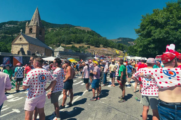 Cycling fans lining the route up Alpe d'Huez during the 2022 edition of the Tour de France and the riders passing through