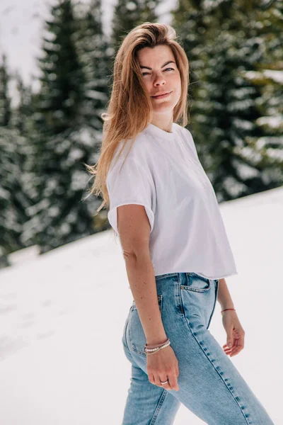 Beautiful Caucasian female in trendy fashion outfit posing against mountain forest — Stock Photo, Image