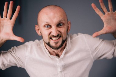 Stüdyo portresi, siyah arka planda güzel sakallı kel bir adamın parmaklarıyla.