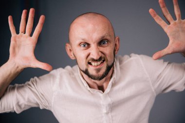 Stüdyo portresi, siyah arka planda güzel sakallı kel bir adamın parmaklarıyla.