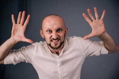 Stüdyo portresi, siyah arka planda güzel sakallı kel bir adamın parmaklarıyla.