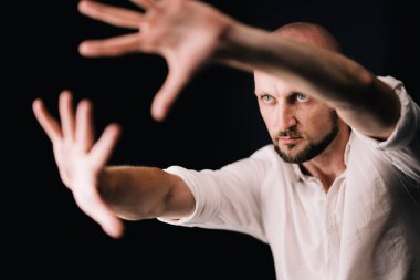 Stüdyo portresi, siyah arka planda güzel sakallı kel bir adamın parmaklarıyla.