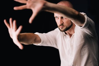 Stüdyo portresi, siyah arka planda güzel sakallı kel bir adamın parmaklarıyla.