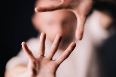 Stüdyo portresi, siyah arka planda güzel sakallı kel bir adamın parmaklarıyla.