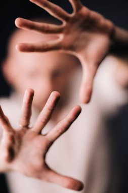 Stüdyo portresi, siyah arka planda güzel sakallı kel bir adamın parmaklarıyla.