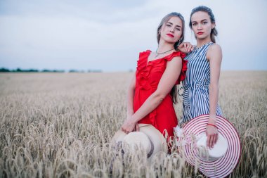 Buğday tarlasında birbirine aşık olan iki genç kız ve güzel şapkalar. LGBT. Yüksek kalite fotoğraf