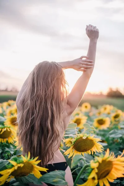 一个年轻的 赤裸的 细长的 蓬松的头发的女孩 日落时用向日葵包裹着她的身体 高质量的照片 — 图库照片