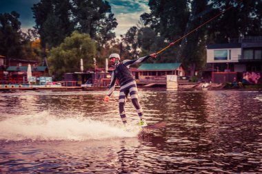 Gün batımında Tibet öküzü kostümü giymiş bir adam Kiev 'deki aşırı parktaki bir wakeboard üzerinde sıçrama tahtasından atlıyor. Ukrayna. Yüksek kalite fotoğraf