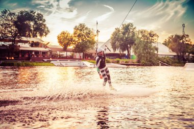 Gün batımında Tibet öküzü kostümü giymiş bir adam Kiev 'deki aşırı parktaki bir wakeboard üzerinde sıçrama tahtasından atlıyor. Ukrayna. Yüksek kalite fotoğraf