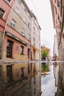 24.09.2022 Ukrayna. Lviv. 4.10.2022 Eski Lviv şehrinin tarihi merkezine doğru yürü. Şehrin su birikintilerindeki yansıması. Yüksek kalite fotoğraf