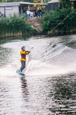 Gün batımında Tibet öküzü kostümü giymiş bir adam Kiev 'deki aşırı parktaki bir wakeboard üzerinde sıçrama tahtasından atlıyor. Ukrayna. Yüksek kalite fotoğraf