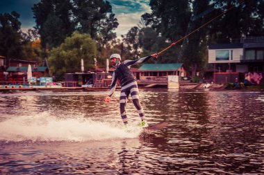 Gün batımında Tibet öküzü kostümü giymiş bir adam Kiev 'deki aşırı parktaki bir wakeboard üzerinde sıçrama tahtasından atlıyor. Ukrayna. Yüksek kalite fotoğraf