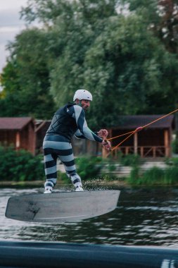 Gün batımında Tibet öküzü kostümü giymiş bir adam Kiev 'deki aşırı parktaki bir wakeboard üzerinde sıçrama tahtasından atlıyor. Ukrayna. Yüksek kalite fotoğraf