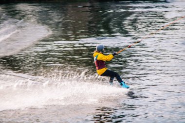 Gün batımında Tibet öküzü kostümü giymiş bir adam Kiev 'deki aşırı parktaki bir wakeboard üzerinde sıçrama tahtasından atlıyor. Ukrayna. Yüksek kalite fotoğraf