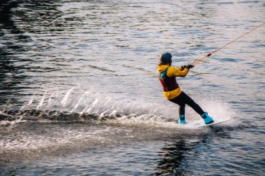 Gün batımında Tibet öküzü kostümü giymiş bir adam Kiev 'deki aşırı parktaki bir wakeboard üzerinde sıçrama tahtasından atlıyor. Ukrayna. Yüksek kalite fotoğraf