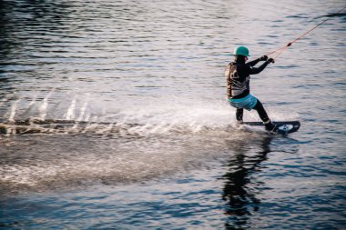 Gün batımında Tibet öküzü kostümü giymiş bir adam Kiev 'deki aşırı parktaki bir wakeboard üzerinde sıçrama tahtasından atlıyor. Ukrayna. Yüksek kalite fotoğraf