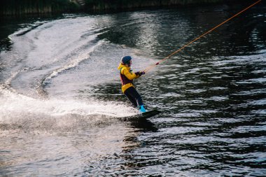 Gün batımında Tibet öküzü kostümü giymiş bir adam Kiev 'deki aşırı parktaki bir wakeboard üzerinde sıçrama tahtasından atlıyor. Ukrayna. Yüksek kalite fotoğraf