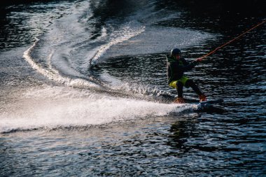 Gün batımında Tibet öküzü kostümü giymiş bir adam Kiev 'deki aşırı parktaki bir wakeboard üzerinde sıçrama tahtasından atlıyor. Ukrayna. Yüksek kalite fotoğraf