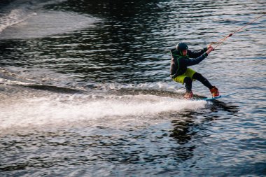 Gün batımında Tibet öküzü kostümü giymiş bir adam Kiev 'deki aşırı parktaki bir wakeboard üzerinde sıçrama tahtasından atlıyor. Ukrayna. Yüksek kalite fotoğraf