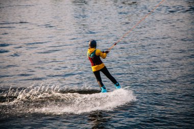 Gün batımında Tibet öküzü kostümü giymiş bir adam Kiev 'deki aşırı parktaki bir wakeboard üzerinde sıçrama tahtasından atlıyor. Ukrayna. Yüksek kalite fotoğraf