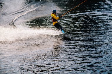 Gün batımında Tibet öküzü kostümü giymiş bir adam Kiev 'deki aşırı parktaki bir wakeboard üzerinde sıçrama tahtasından atlıyor. Ukrayna. Yüksek kalite fotoğraf