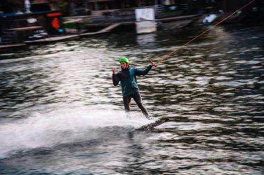 Gün batımında Tibet öküzü kostümü giymiş bir adam Kiev 'deki aşırı parktaki bir wakeboard üzerinde sıçrama tahtasından atlıyor. Ukrayna. Yüksek kalite fotoğraf