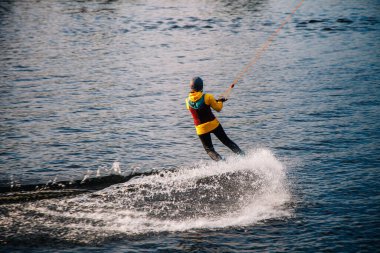 Gün batımında Tibet öküzü kostümü giymiş bir adam Kiev 'deki aşırı parktaki bir wakeboard üzerinde sıçrama tahtasından atlıyor. Ukrayna. Yüksek kalite fotoğraf